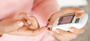 Personne utilisant un glucomètre pour mesurer la glycémie capillaire, pratique essentielle pour la gestion du diabète.
